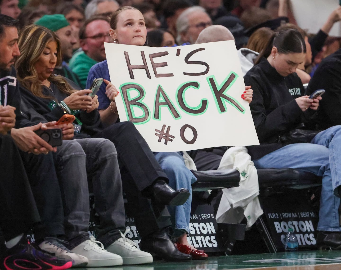 A Celtics fan welcomes back Jayson Tatum during first-quarter action Friday.