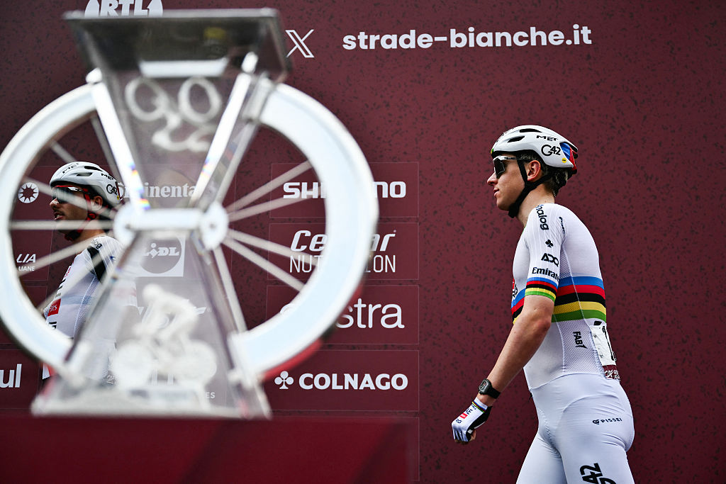 UAE Team Emirates's Slovenian Tadej Pogacar walks past the trophy ahead of the 20th one-day classic 'Strade Bianche' (White Roads) men's cycling race between Siena and Siena in Tuscany on March 7, 2026. (Photo by Marco BERTORELLO / AFP)