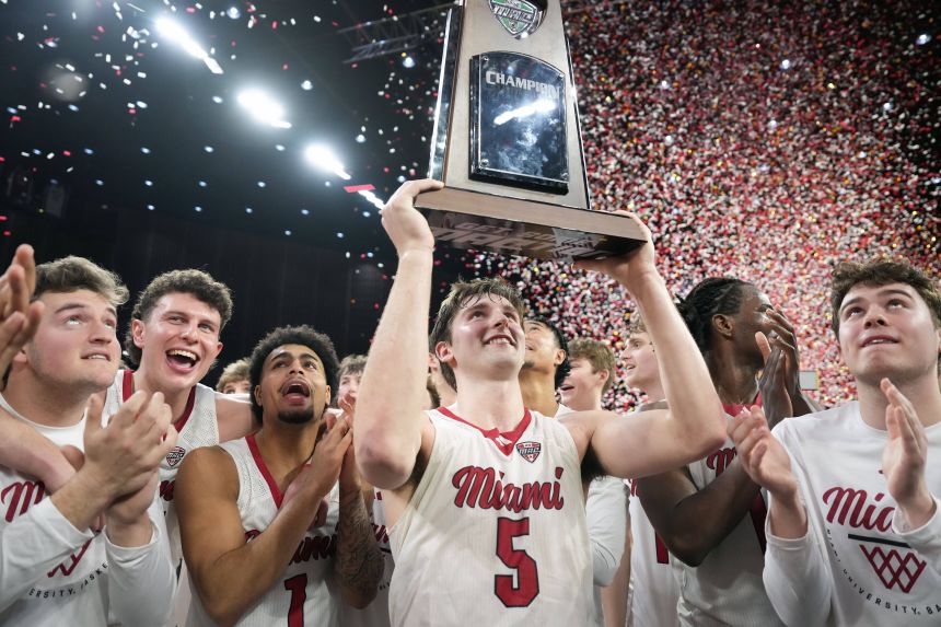 Peter Suder raises the MAC regular-season trophy as the RedHawks celebrate on March 3.