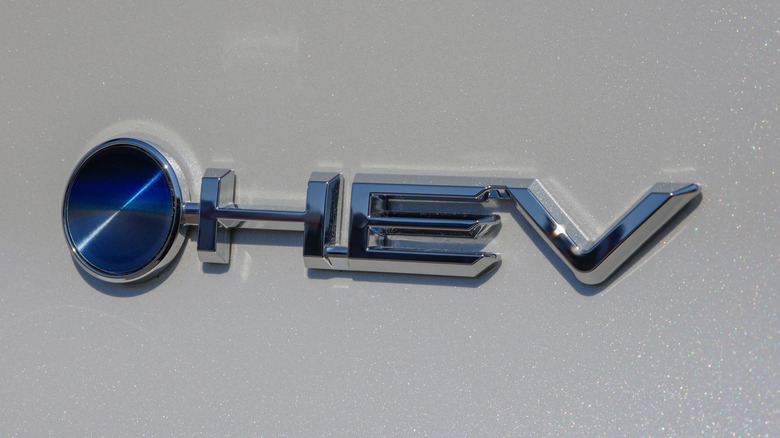 The blue dot Beyond Zero and HEV badge on a new Toyota electrified vehicle