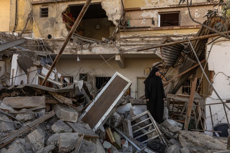 A Lebanese woman stands inside the ruins of her home, destroyed in an Israeli airstrike in Tyre, southern Lebanon, on March 24, 2026.