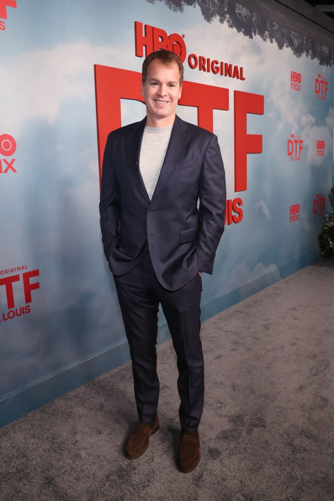 Casey Bloys, Chairman and CEO of HBO and Max Content, smiling in a navy suit and light gray shirt against a backdrop for "HBO Original DTF St. Louis."