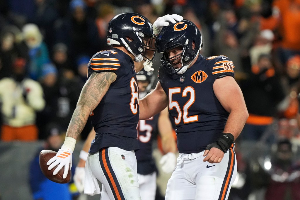 Chicago Bears tight end Colston Loveland celebrating with teammate Drew Dalman after catching a touchdown pass.