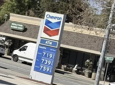 Gas station sign showing prices: $7.19 Regular, $7.39 Plus, $7.59 Supreme, viewed from a car window