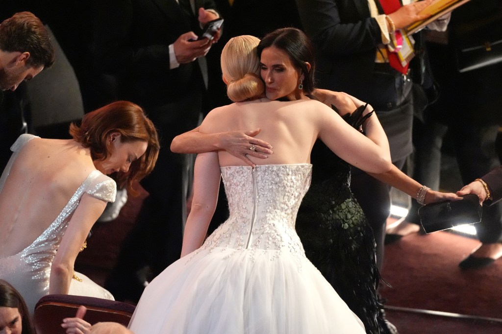 Demi Moore, right, embraces Elle Fanning