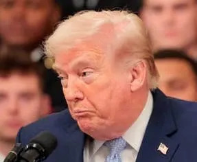 A person speaking at a podium with a group of uniformed individuals standing behind them