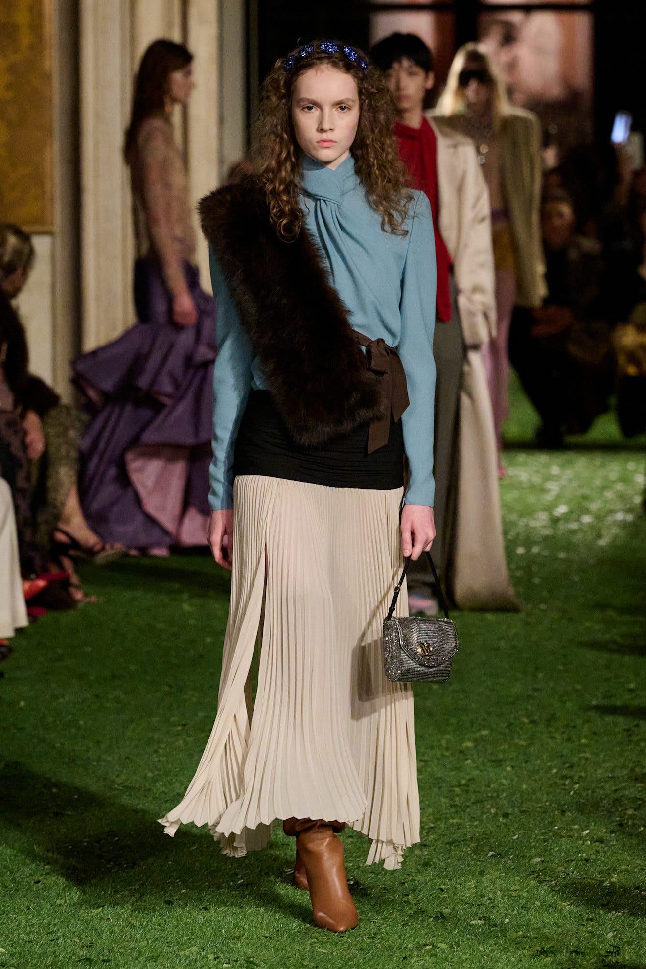 model walking down a runway wearing a fashionable outfit