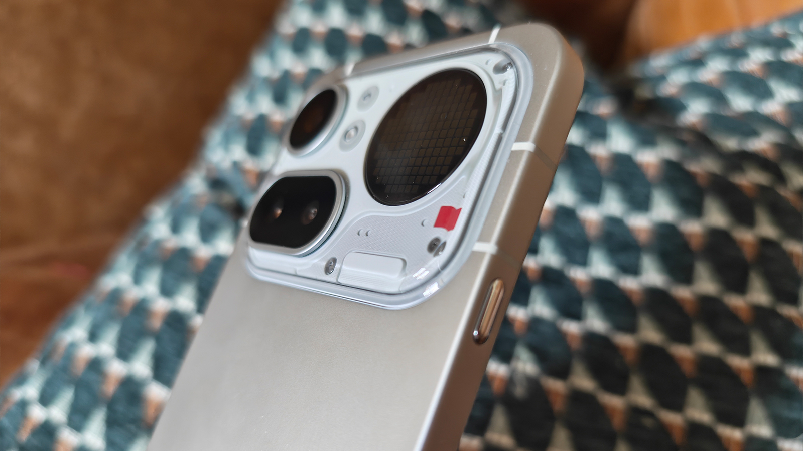 Photos of a silver phone on a cushion