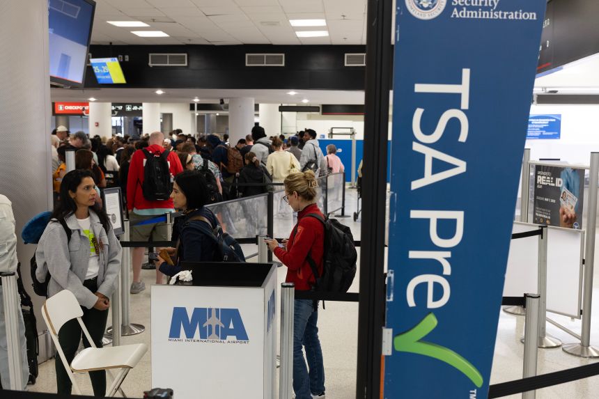 Travelers wait in a TSA Pre security line at Miami International Airport on March 17, in Miami.