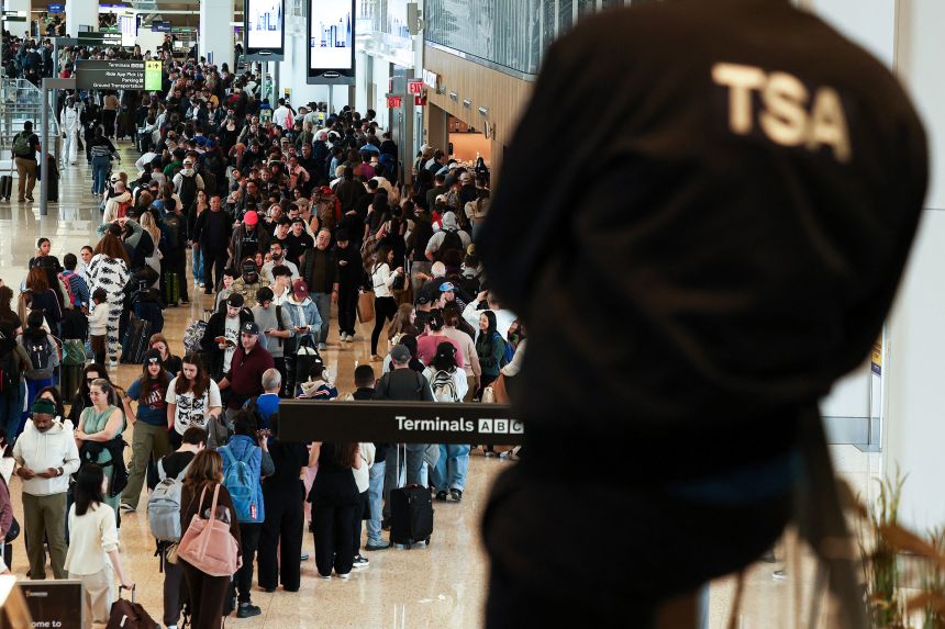 A Transportation Security Administration agent looks the line to go through security at New York's LaGuardia airport on March 22, 2026.