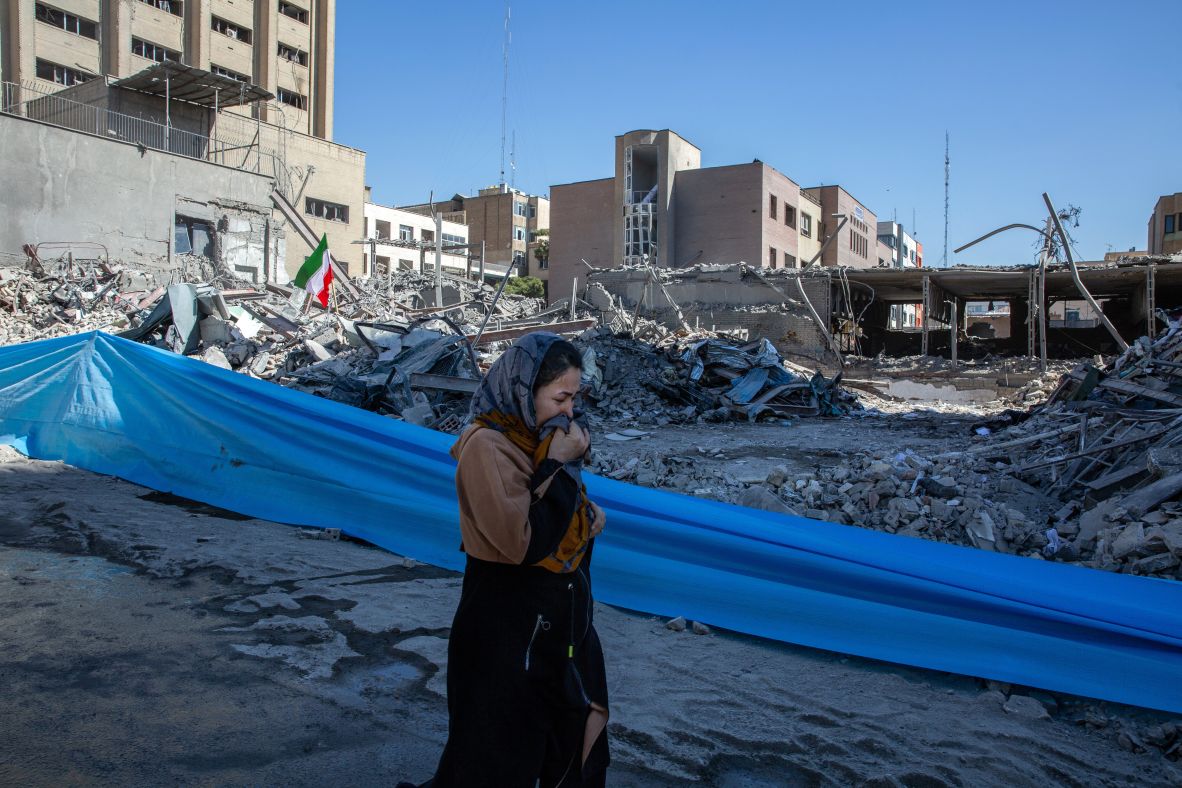 A woman in Tehran, Iran, walks past the wreckage of a police station Tuesday that was destroyed by US-Israeli airstrikes.