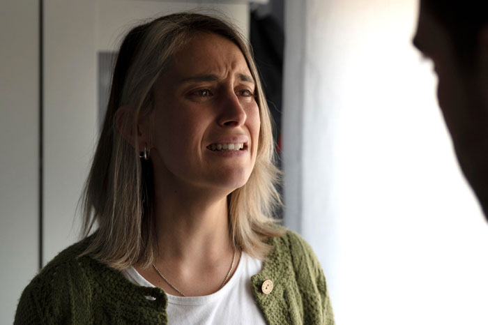 Woman looking upset and emotional during a tense conversation, capturing feelings of betrayal and departure in a personal moment.