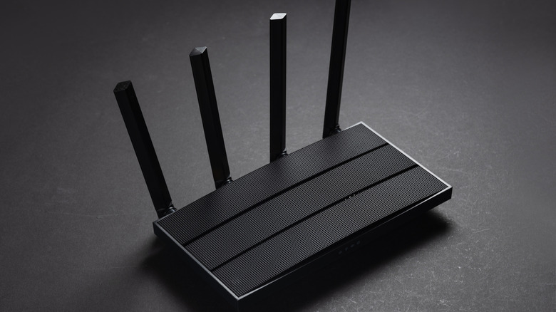 Modern stylish Wi-Fi router with antennas on a dark background.