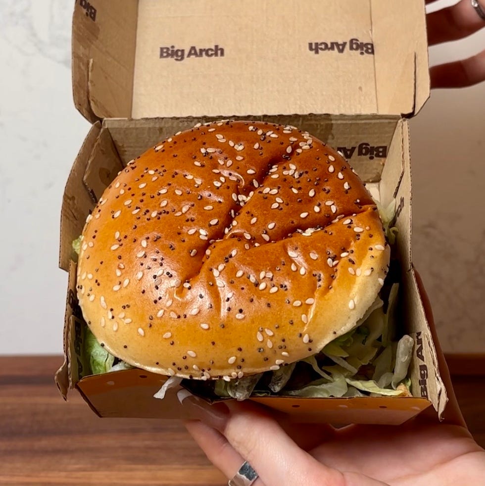 takeout burger box with a sesame seed bun visible