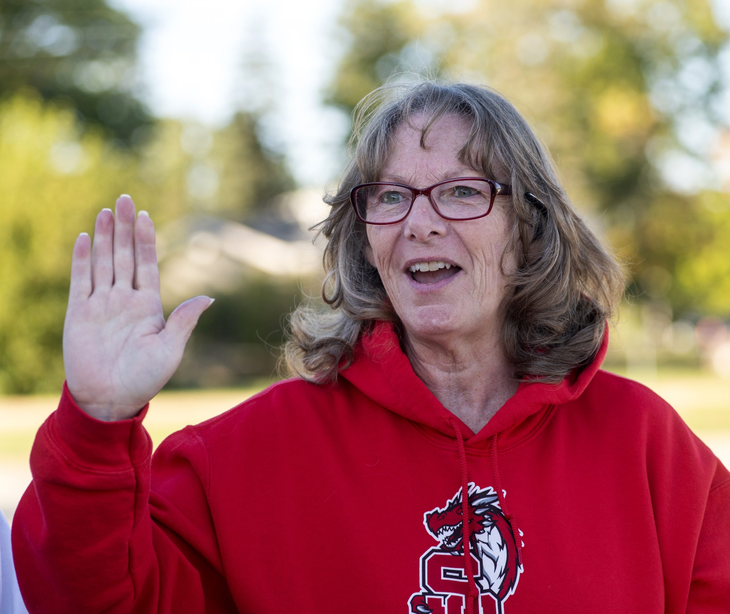 A portrait of Sue Dishaw. She is wearing a red sweatshirt. 