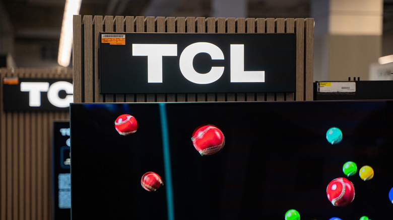 TCL sign in electronic store, with TV visible in the foreground, bright colors
