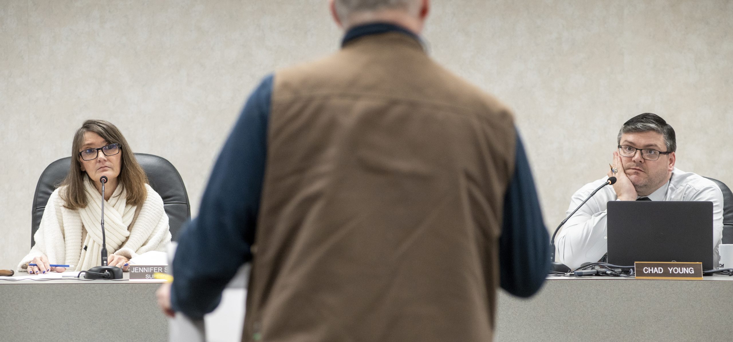 A man talking in front of a Board of Trustees meeting. 