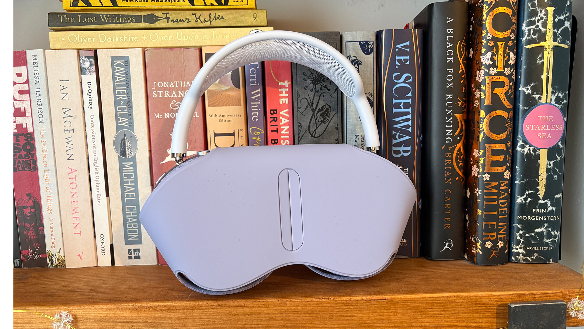 Apple AirPods Max 2 over-ear headphones in case on bookshelf