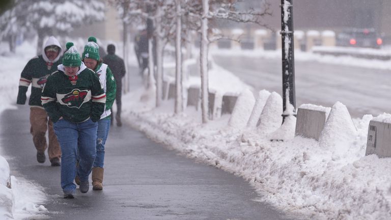 NHL fans walk through snowy streets in St Paul, Minnesota. Pic: AP 