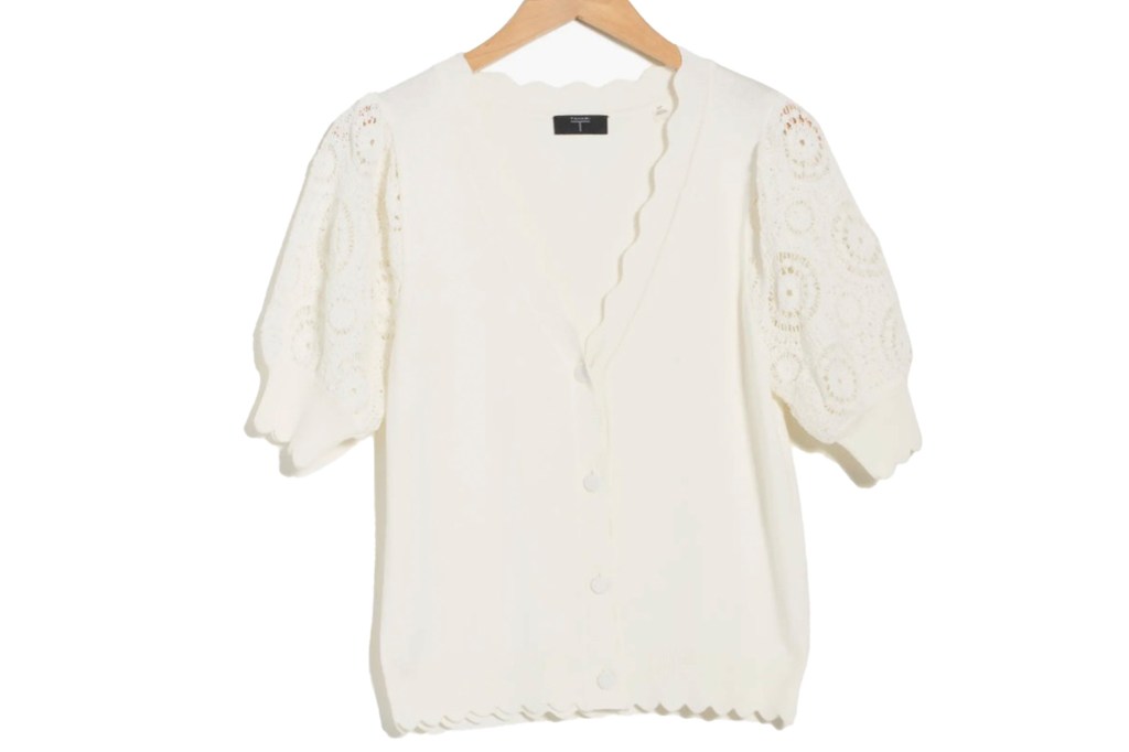White cardigan with short lace puff sleeves and a scalloped hem.
