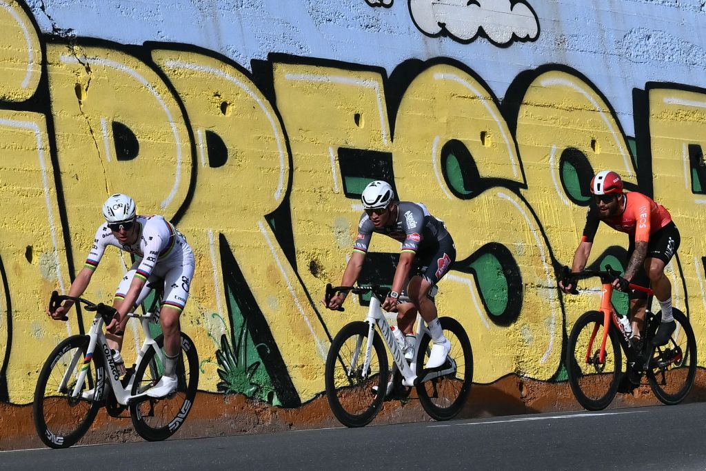 Team UAE's Slovenian rider Tadej Pogacar (L), Dutch Mathieu Van Der Poel of team Alpecin-Deceuninck (C) and Team Ineos' Italian rider Filippo Ganna prepare to take a turn in la Cipressa downhill during the Milan - Sanremo one-day classic cycling race, on March 22, 2025. (Photo by Marco BERTORELLO / AFP)