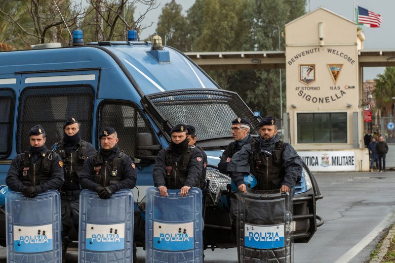 Police officers stand outside Naval Air Station Sigonella in Sicily, Italy, on March 15, 2026, during a protest outside the base against US and Israeli strikes in the Middle East.