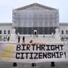 Demonstrators hold up a "Dump Trump" sign and a "Hands Off Birthright Citizenship" banner outside the Supreme Court.