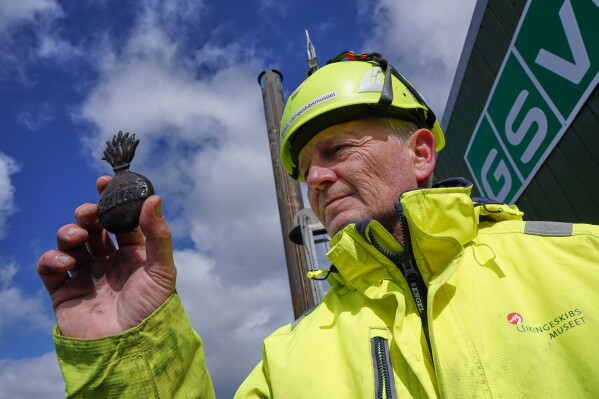 Morten Johansen, head of maritime archaeology at Denmark's Viking Ship Museum, shows a metal insignia recovered from the wreck of Danish flagship "Dannebroge" that sank during the Battle of Copenhagen in 1801, in Copenhagen, Denmark, Tuesday, March 31, 2026. (AP Photo/James Brooks)