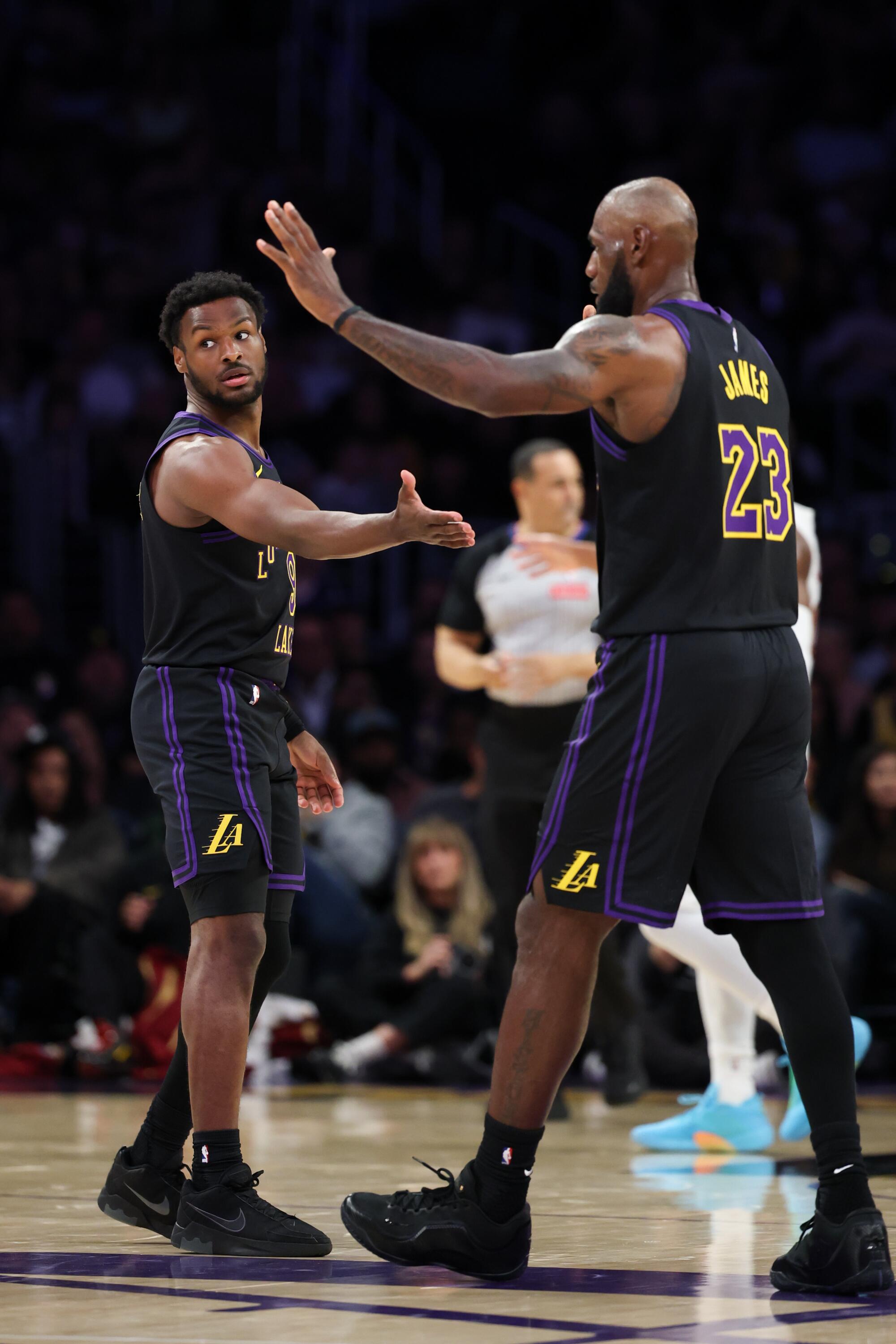 Lakers guard Bronny James, left, celebrates with his father and teammate LeBron James.