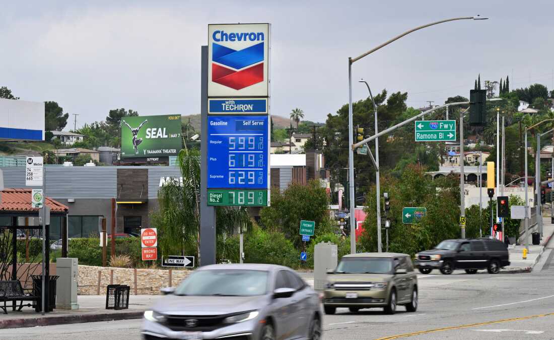 Gas prices are displayed on a large sign at a Chevron gas station in Los Angeles on March 31. Cars drive by on the street.
