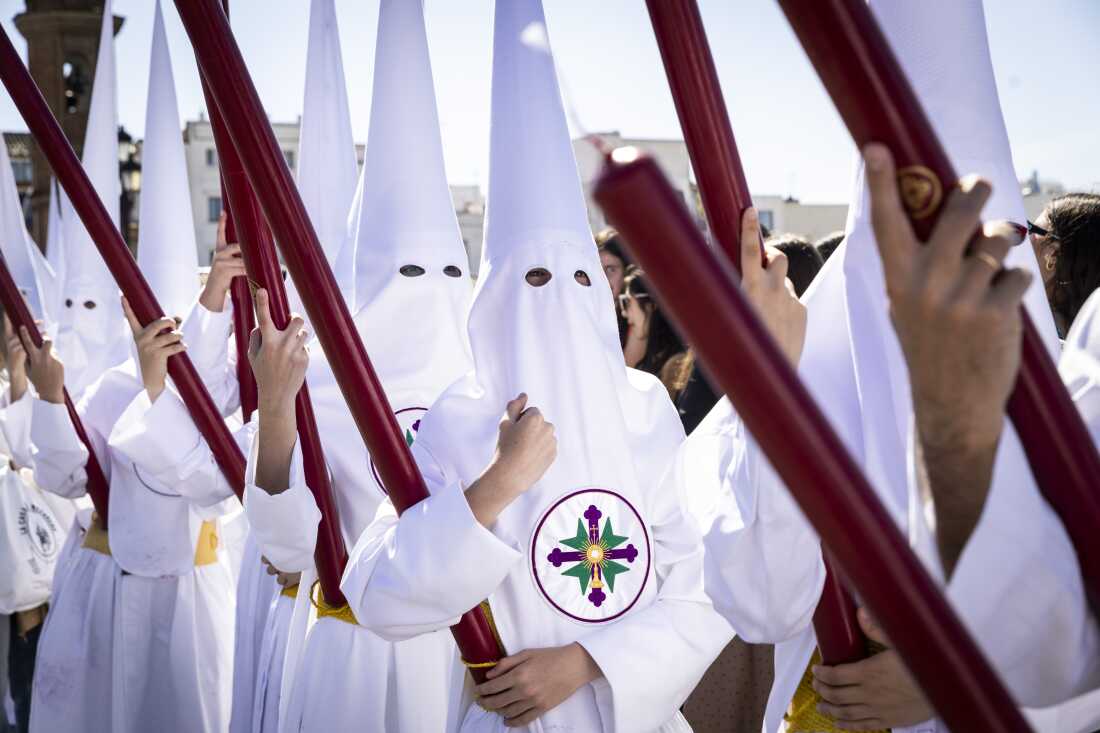 Nazarenos from the brotherhood of San Gonzalo cross Isabel II bridge, known as Puente de Triana, on their way to the Cathedral.