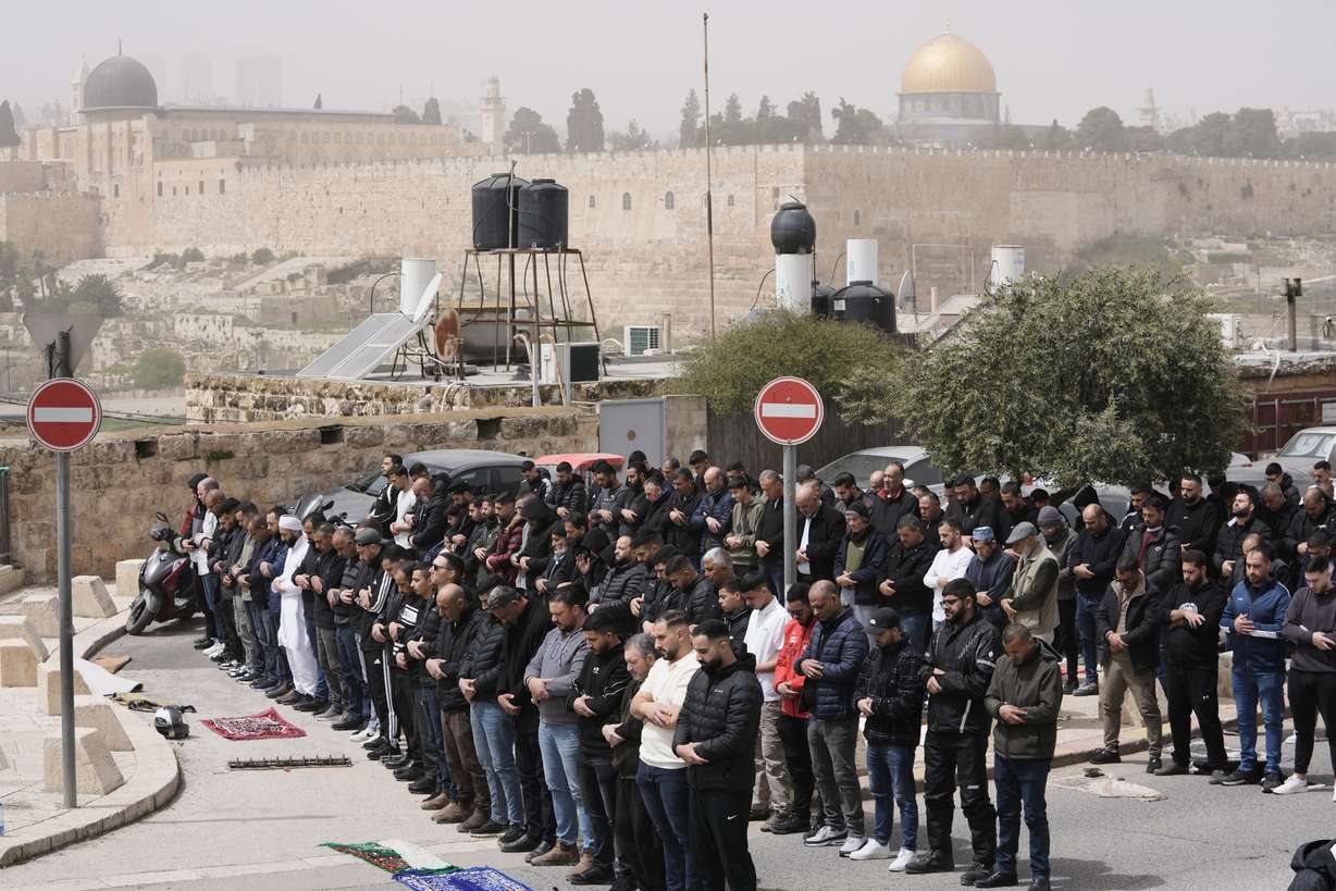 Palestinian Muslims attend Friday prayers outside Jerusalem's Old City due to restrictions linked to the Iran war, Friday. An Israeli drone strike in Lebanon killed two people attending Friday worship.