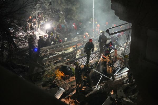 Israeli security forces and rescue teams work amid the rubble of a residential building struck by an Iranian missile in Haifa, Israel, Sunday, April 5, 2026. (AP Photo/Ariel Schalit)