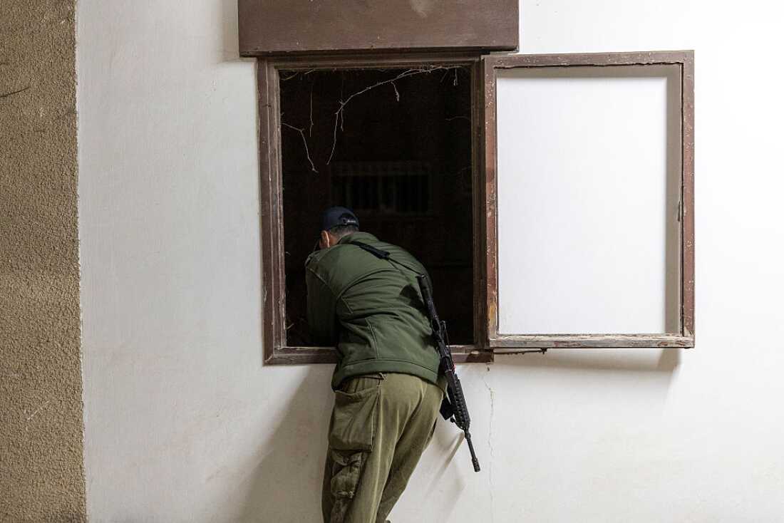 An Israeli soldier overlooks the scene as search and rescue personnel work at the site of a residential building destroyed in an Iranian strike in the northern city of Haifa on April 5, 2026.