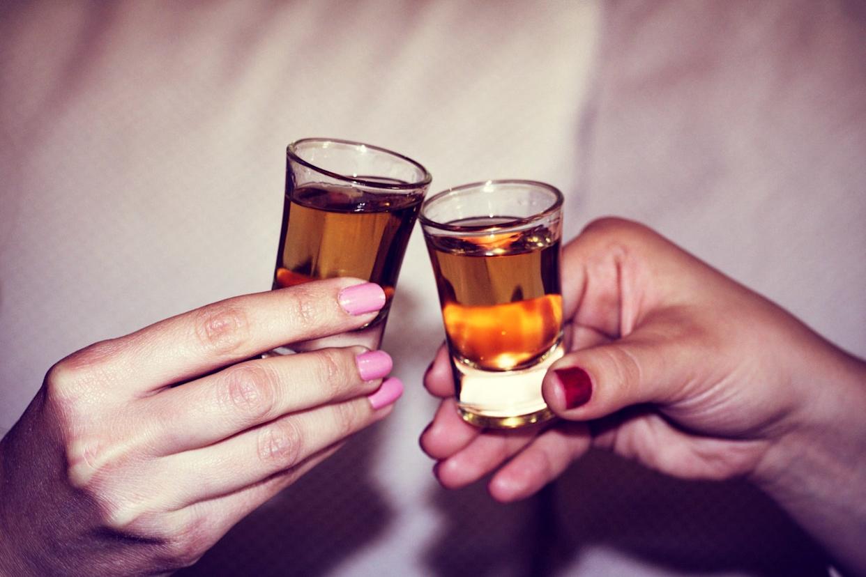 Two hands toasting whiskey on the rock, with isolated background