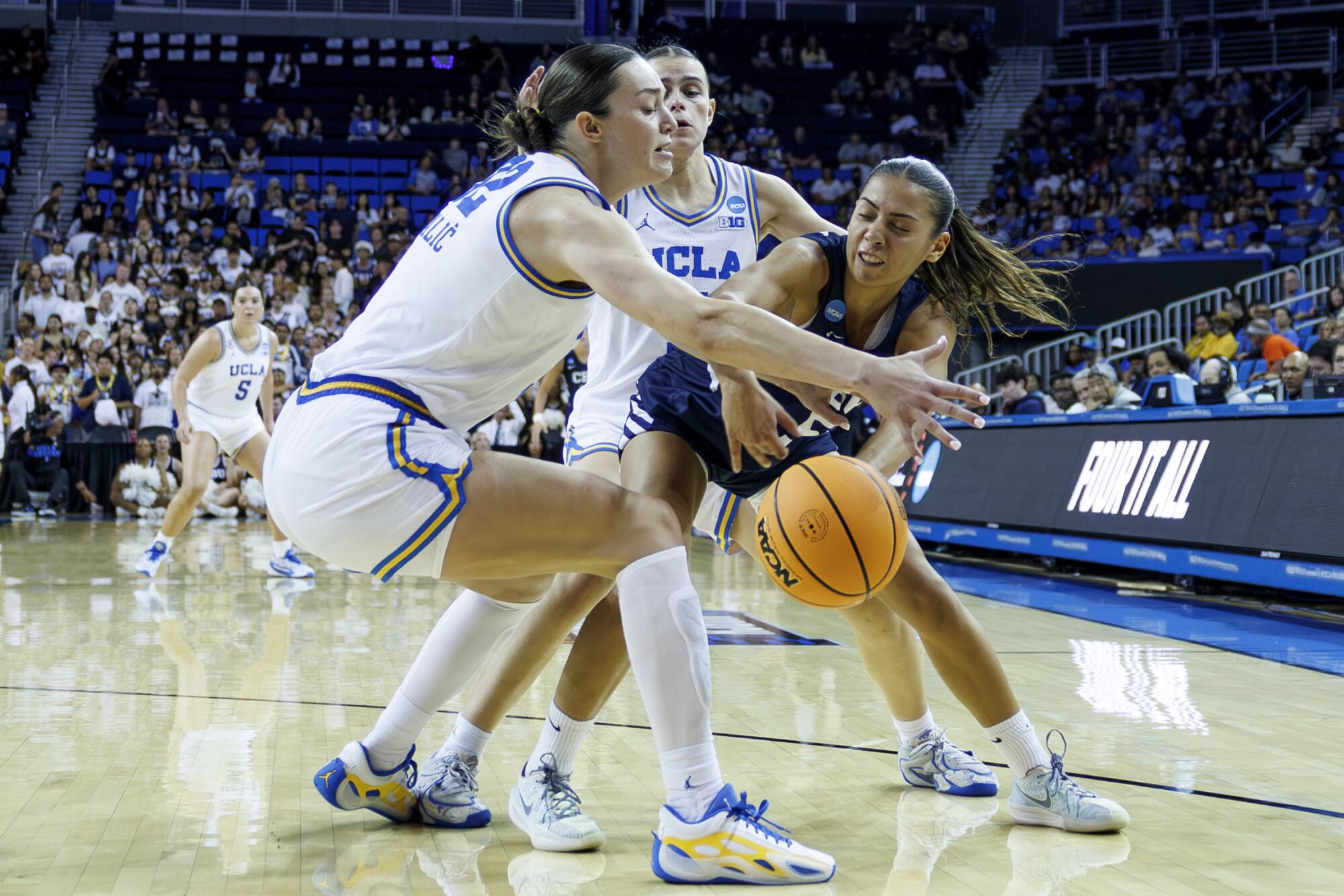 UCLA Bruins forwards Angela Dugalic and Gabriela Jaquez double team California Baptist guard Filipa Barros.