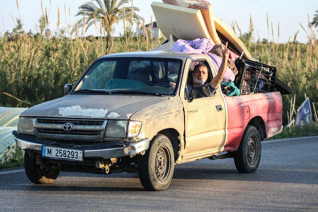A man flashes the V-sign while driving a vehicle loaded with belongings through the al-Qassimyah area en route to southern Lebanon early on April 8, 2026, after the United States and Iran agreed to a two-week ceasefire. Israel renewed its strikes on southern Lebanon on April 8, state media reported, as the Israeli prime minister insisted the Iran war truce does not include Lebanon.
