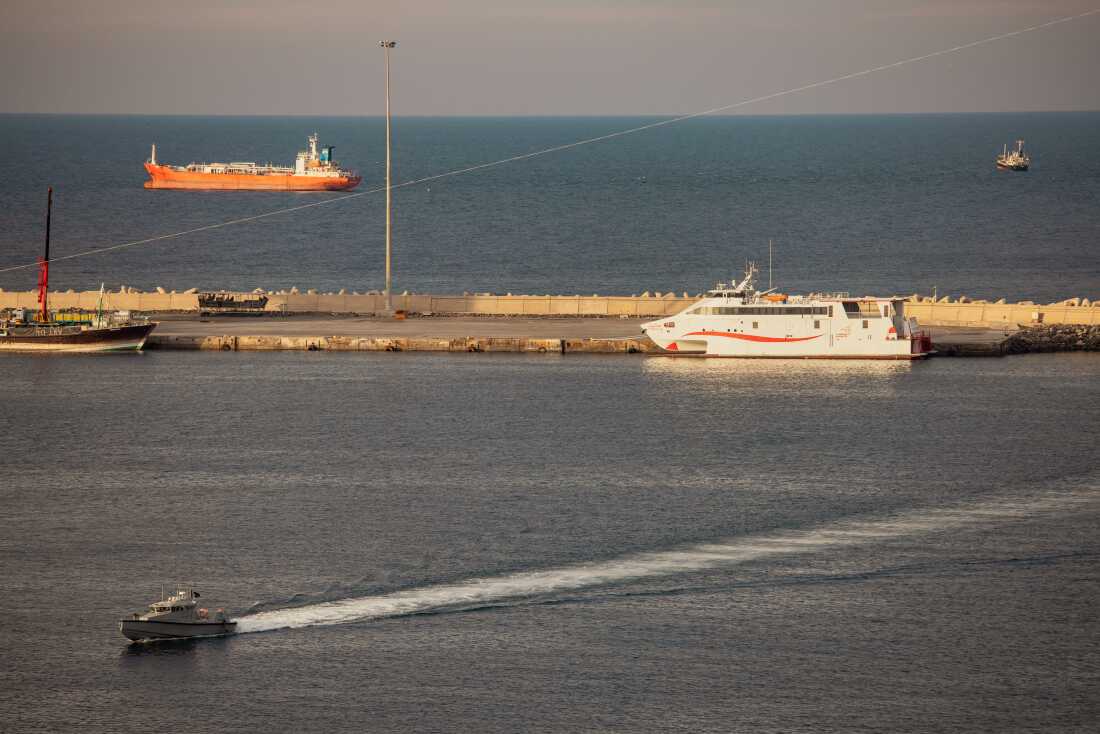 A police speed boat patrols the port as oil tankers and high speed crafts sit anchored near the Strait of Hormuz on March 30 in Muscat, Oman. The war led to the shutdown of tanker traffic through the vital waterway.