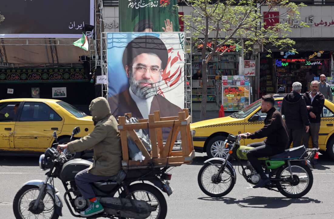 Motorists ride past a banner depicting Iran's new supreme leader, Ayatollah Mojtaba Khamenei, in Tehran on Sunday.