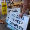 Volunteers hand out yard signs in June against a data center complex in West Virginia.