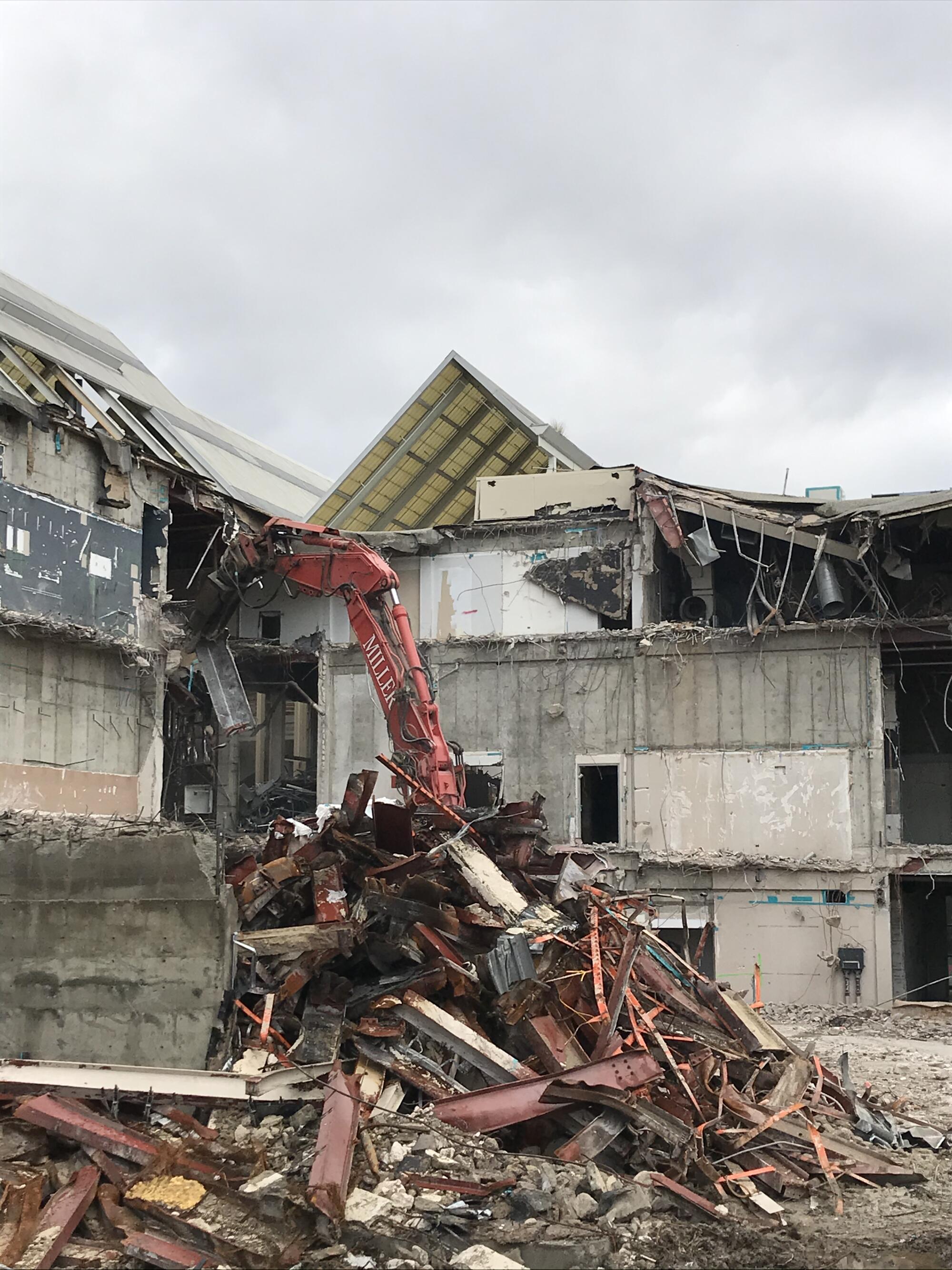 An excavator demolishes a theater.