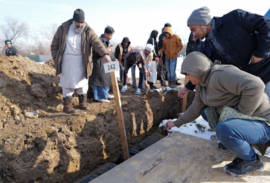 Community members and loved ones toss soil on the burial site of Nurul Amin Shah Alam during his funeral service in Buffalo, New York, on February 26.