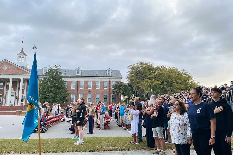 Families saluted and honored the American flag as a Marine sang the American anthem. (Suzanne Gamboa / NBC News)