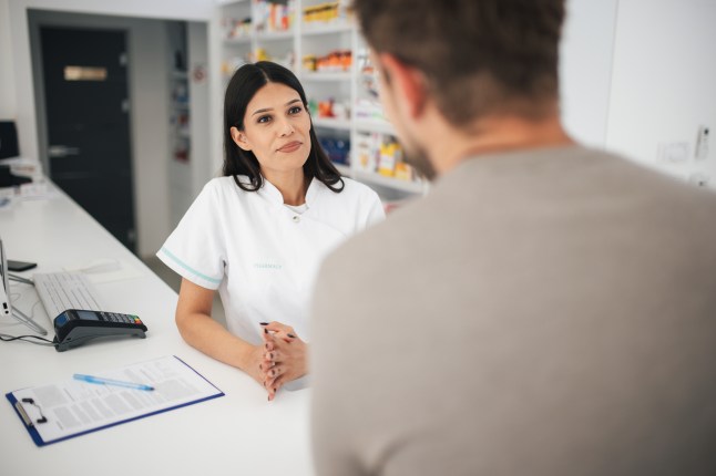 Pharmacist explaining prescription to customer, patient guidance and support in pharmacy