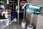 FILE - Health department staff members enter the Andrews County Health Department measles clinic carrying doses of the measles, mumps and rubella vaccine, Tuesday, April 8, 2025, in Andrews, Texas.