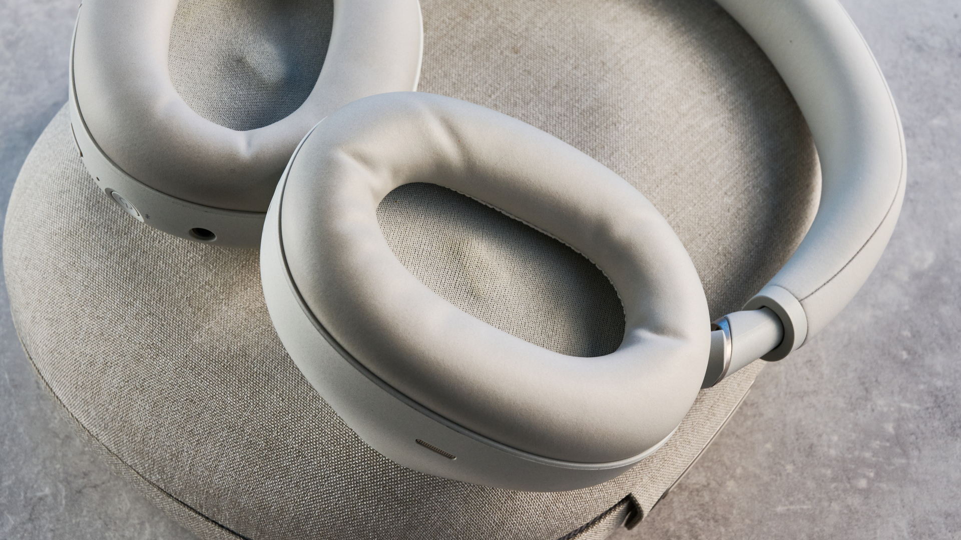 the sony wh-1000xm6 headphones in beige photographed against the blue tom's guide background