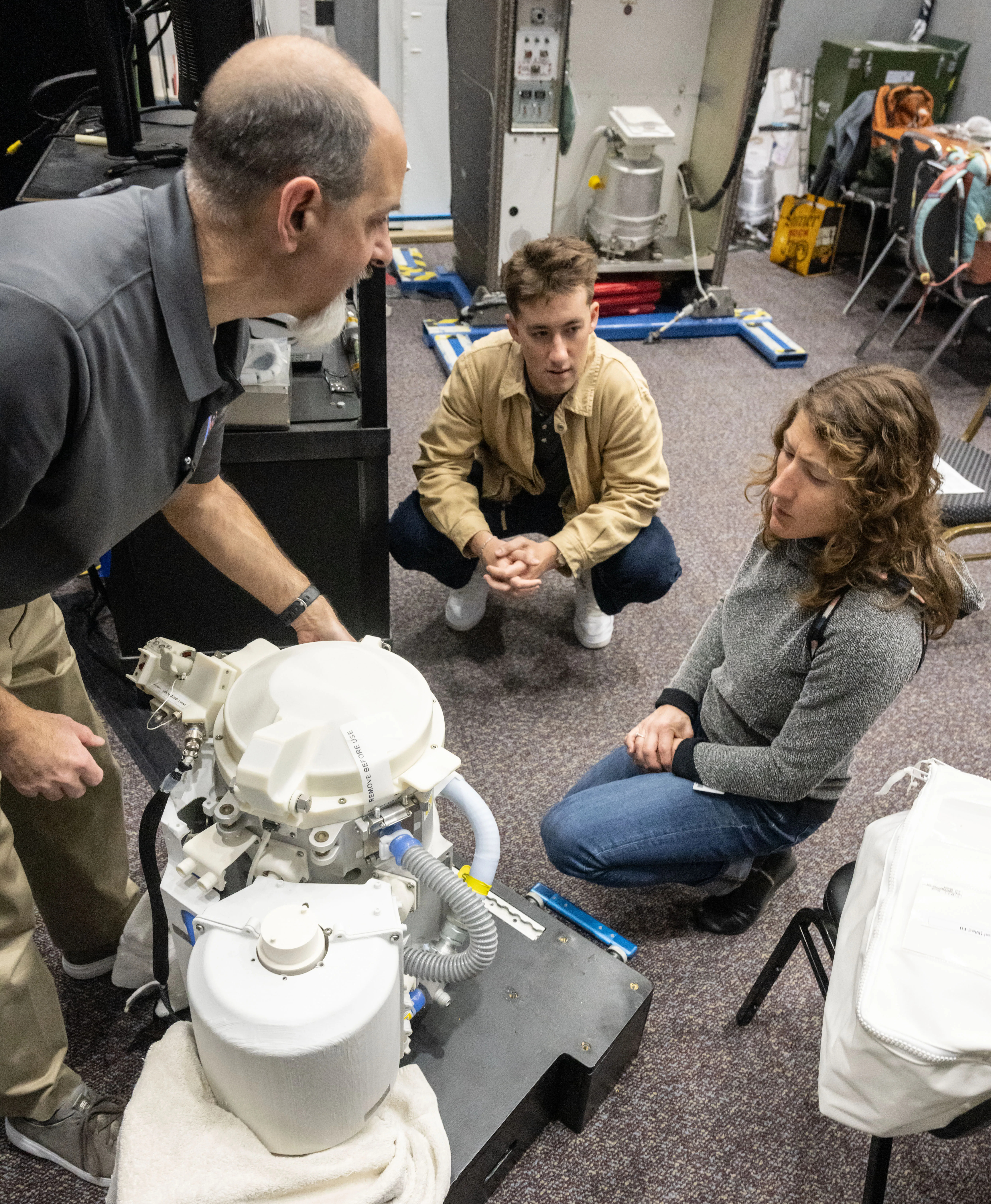 NASA astronaut Christina Koch works with a test version of the Orion space toilet.