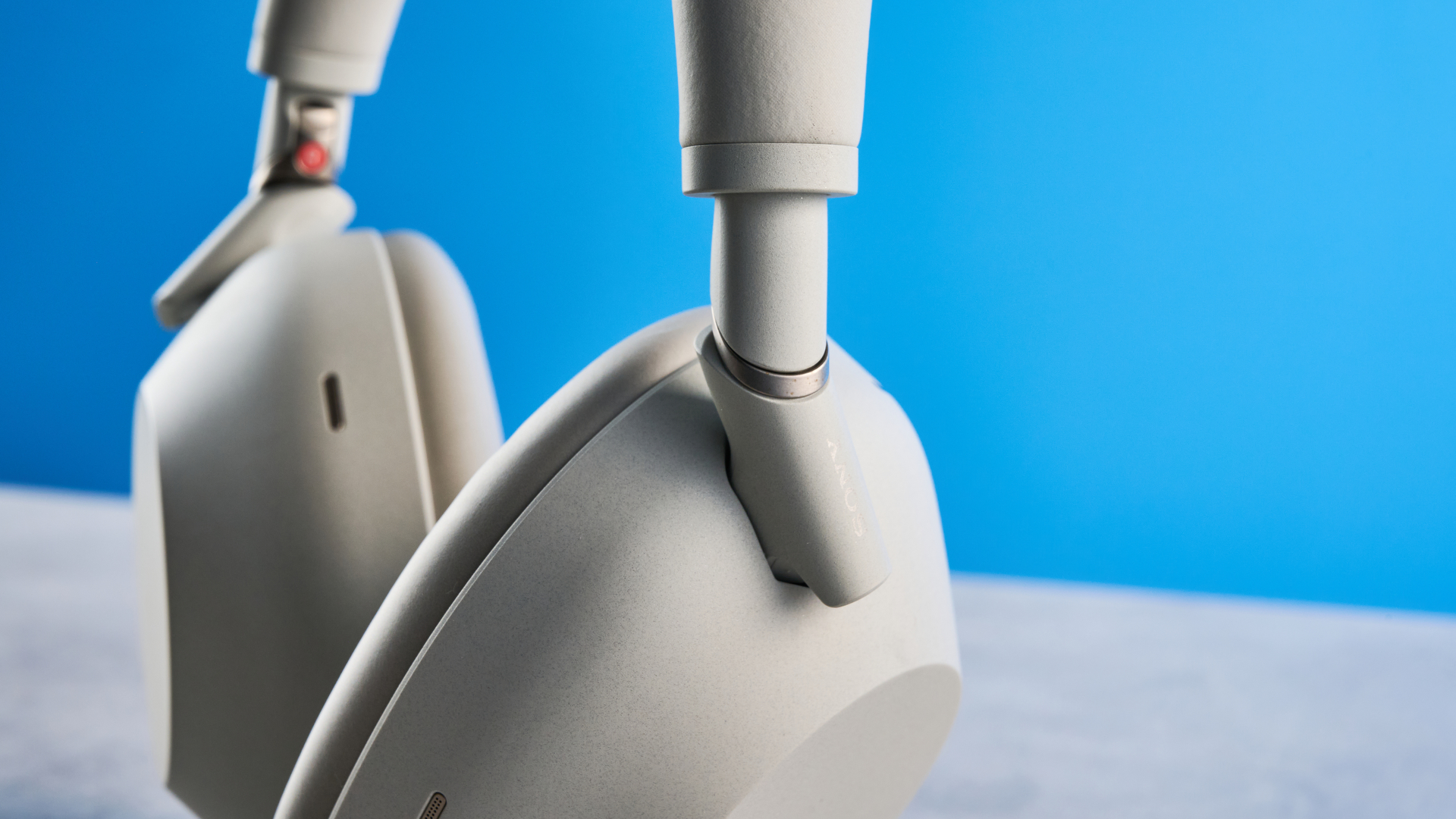 the sony wh-1000xm6 headphones in beige photographed against the blue tom's guide background