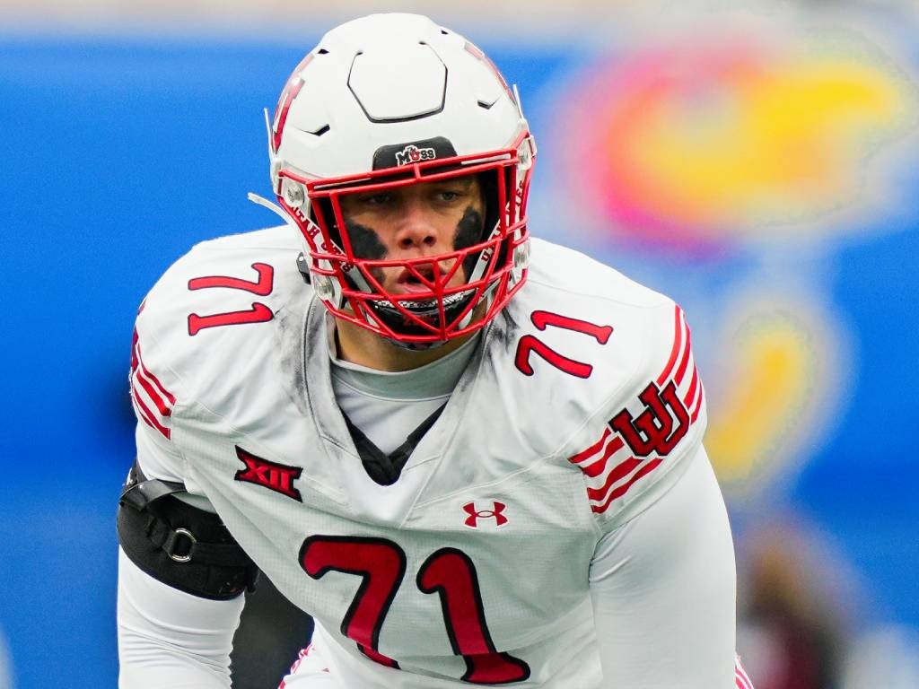 Nov 28, 2025; Lawrence, Kansas, USA; Utah Utes offensive lineman Caleb Lomu (71) gets ready before the snap during the second half against the Kansas Jayhawks at David Booth Kansas Memorial Stadium. Mandatory Credit: Jay Biggerstaff-Imagn Images