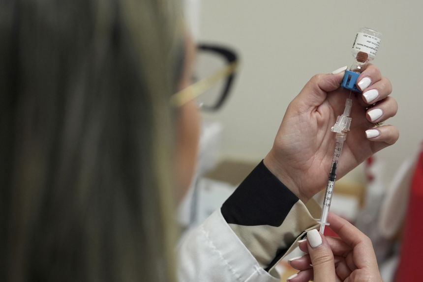 A pharmacy manager draws a dose of respiratory syncytial virus (RSV) vaccine into a syringe as she prepares a shot for a patient in Miami in September 2025.